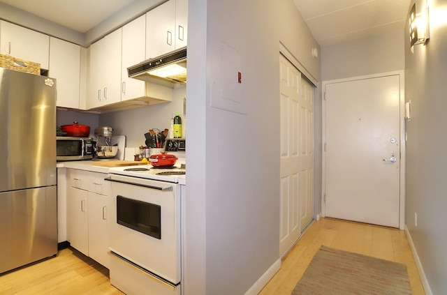 kitchen with stainless steel appliances, under cabinet range hood, light countertops, white cabinetry, and light wood-type flooring