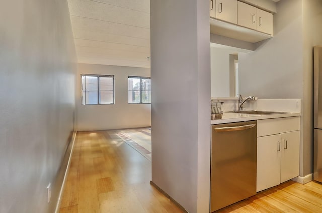 463 1st St Unit 3B, Hoboken, NJ 07030 - kitchen featuring stainless steel dishwasher, a sink, light wood-style flooring, light countertops, and white cabinets