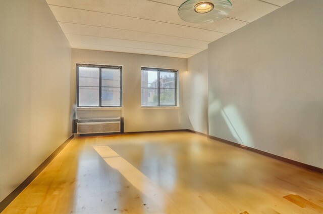 463 1st St Unit 3B, Hoboken, NJ 07030 - empty room featuring wood finished floors, a wall unit AC, and baseboards