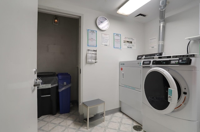 community laundry featuring washing machine and clothes dryer and light floors