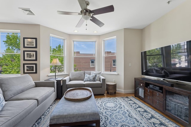 living area featuring wood finished floors, baseboards, ceiling fan, and recessed lighting