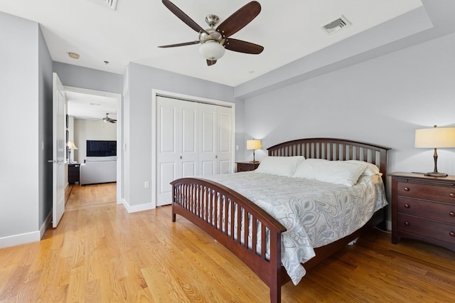 bedroom with light wood-style floors, a closet, baseboards, and a ceiling fan