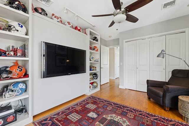 living area featuring ceiling fan, light wood-style floors, and track lighting