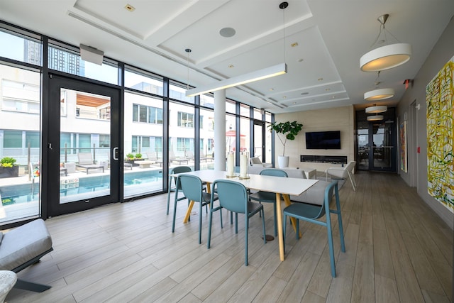 160 1st St Unit 1013, Jersey City, NJ 07302 - dining space with a wall of windows, a tray ceiling, and light wood-style flooring