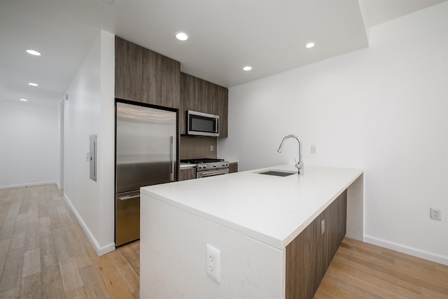 160 1st St Unit 1013, Jersey City, NJ 07302 - kitchen with premium appliances, light wood finished floors, a peninsula, recessed lighting, and modern cabinets