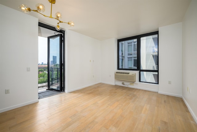 160 1st St Unit 1013, Jersey City, NJ 07302 - unfurnished room featuring a chandelier, light wood-style floors, and a wall mounted air conditioner