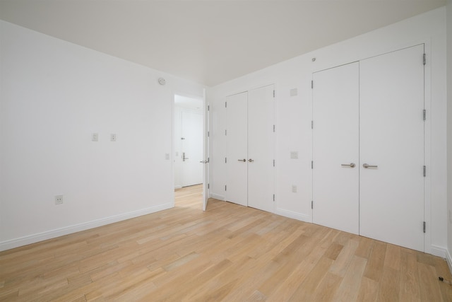 160 1st St Unit 1013, Jersey City, NJ 07302 - unfurnished bedroom with multiple closets and light wood-style floors