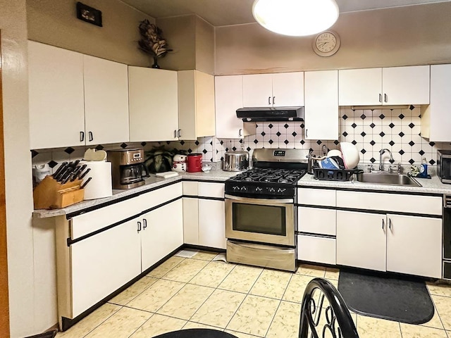 kitchen featuring stainless steel appliances, decorative backsplash, white cabinets, a sink, and under cabinet range hood