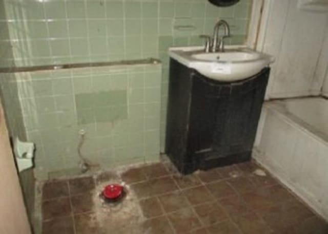 bathroom with tile walls and vanity