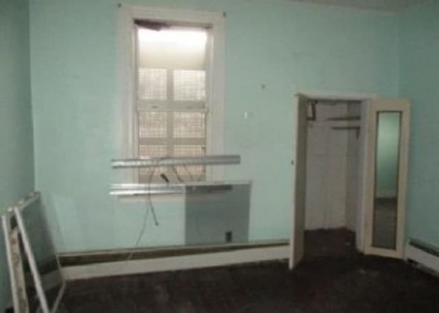 unfurnished room featuring baseboard heating