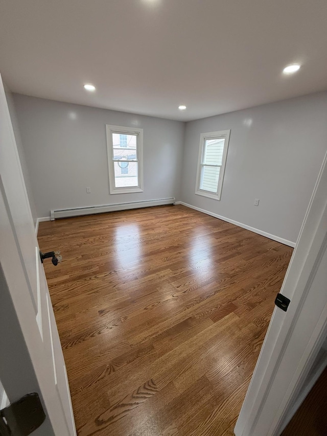 187 Lembeck Ave, Jersey City, NJ 07305 - unfurnished room featuring a baseboard heating unit, plenty of natural light, recessed lighting, and wood finished floors