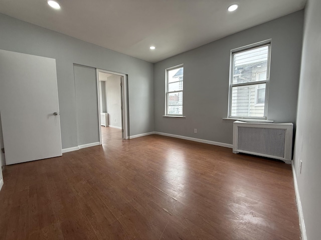 125 W 3rd St, Bayonne, NJ 07002 - spare room featuring radiator heating unit, dark wood-type flooring, baseboards, and recessed lighting