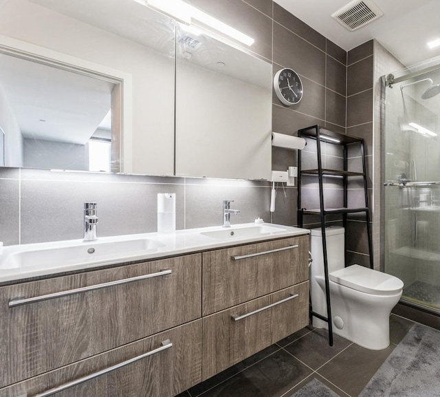 202 Merseles St Unit 504, Jersey City, NJ 07302 - bathroom featuring double vanity, a shower stall, tile patterned floors, and tile walls