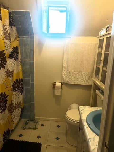 bathroom featuring toilet, vanity, tile patterned flooring, and walk in shower