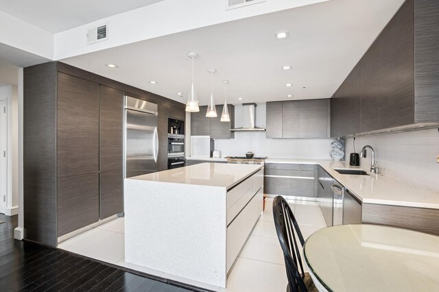 8100 River Rd Unit 1101, North Bergen, NJ 07047 - kitchen with a sink, wall chimney exhaust hood, visible vents, modern cabinets, and appliances with stainless steel finishes