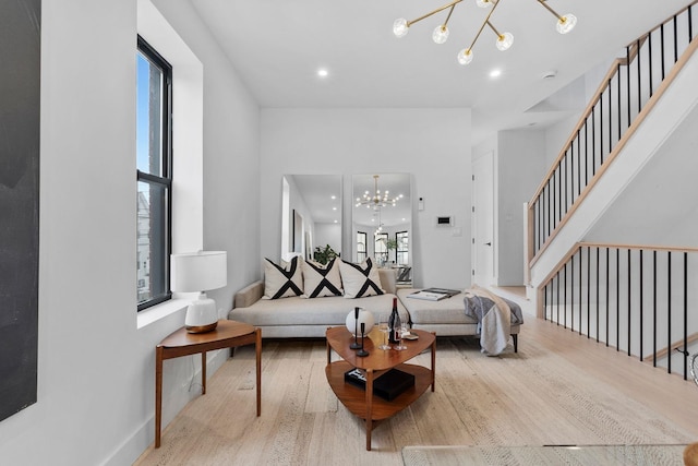 living area with a chandelier, recessed lighting, stairs, and wood finished floors