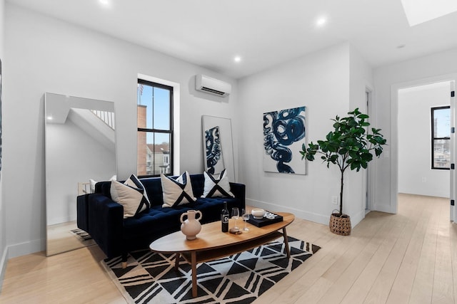 living room featuring recessed lighting, baseboards, light wood-style floors, and a wall mounted AC