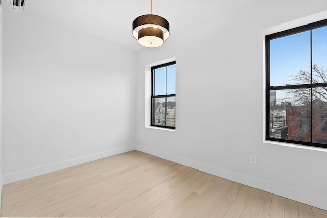 empty room featuring baseboards and wood finished floors