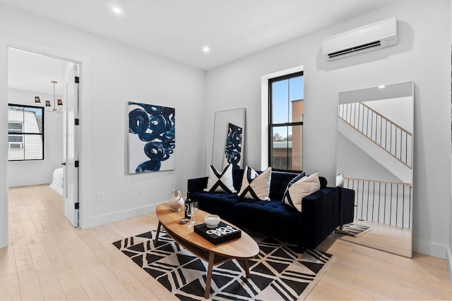 living area featuring a wall mounted air conditioner, baseboards, wood finished floors, and recessed lighting