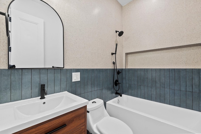 bathroom with shower / bath combination, a wainscoted wall, toilet, and vanity