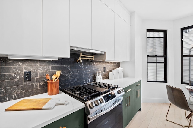 kitchen with stainless steel gas stove, green cabinets, and light countertops