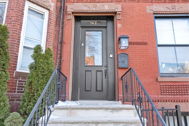 property entrance featuring brick siding