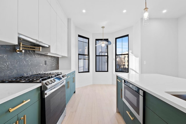 kitchen featuring built in microwave, stainless steel gas stove, white cabinetry, decorative light fixtures, and decorative backsplash