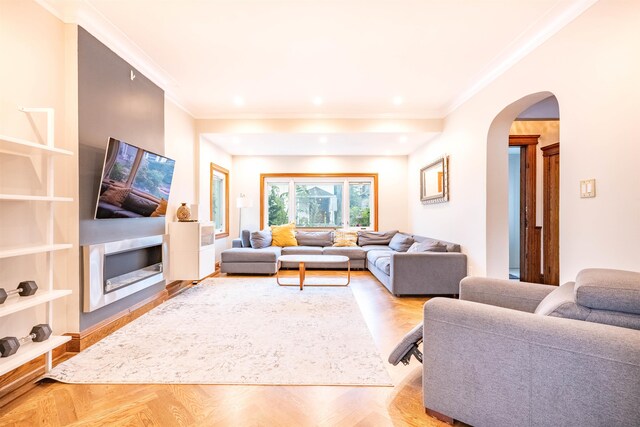 living room featuring light parquet flooring and crown molding