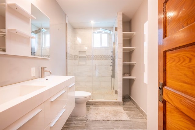 bathroom with a wealth of natural light, vanity, toilet, and a shower with shower door