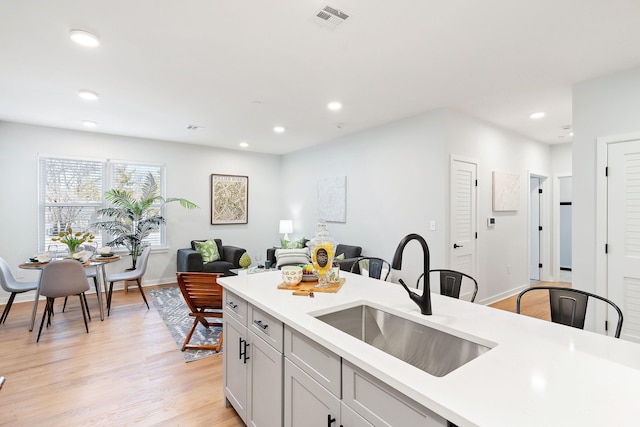 kitchen featuring white cabinets, light hardwood / wood-style floors, and sink