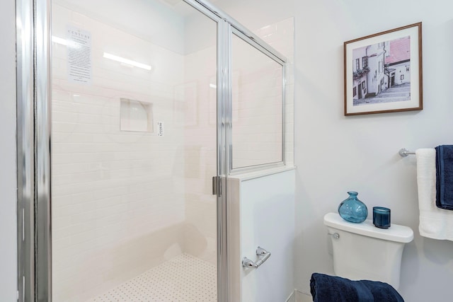 bathroom featuring toilet and a shower with door