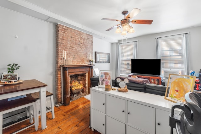 living room with a fireplace, a ceiling fan, and hardwood / wood-style floors