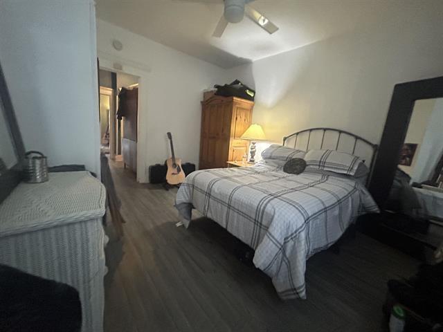 bedroom with dark hardwood / wood-style flooring and ceiling fan