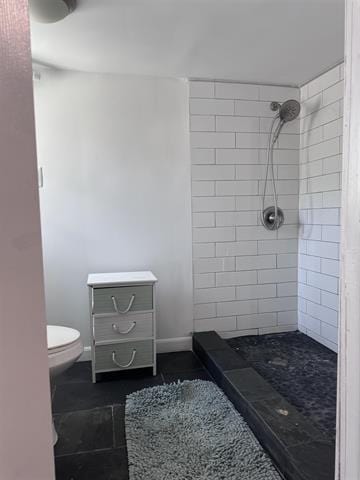 bathroom with toilet and a tile shower