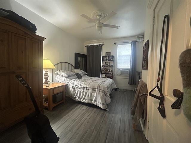 bedroom with ceiling fan, cooling unit, and wood-type flooring