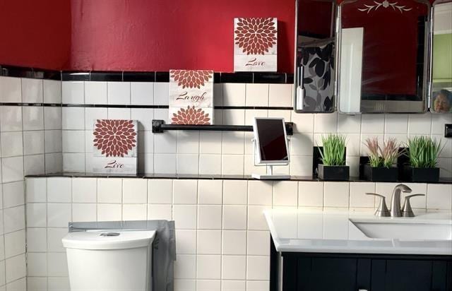 bathroom featuring sink, toilet, and tasteful backsplash