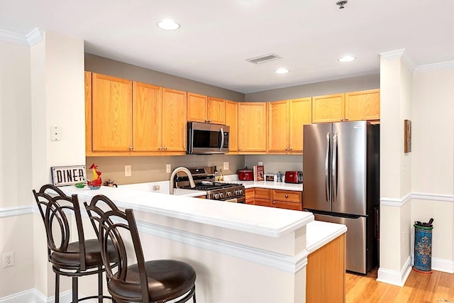 812 Grand St Unit 208, Hoboken, NJ 07030 - kitchen featuring appliances with stainless steel finishes, a peninsula, light countertops, light wood-style flooring, and recessed lighting