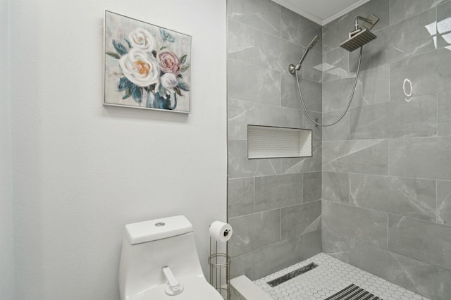 bathroom featuring tiled shower and toilet