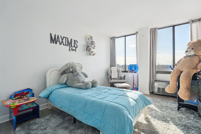 bedroom with baseboards and wood finished floors