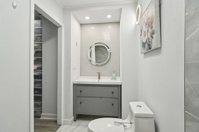 bathroom featuring toilet, baseboards, and vanity