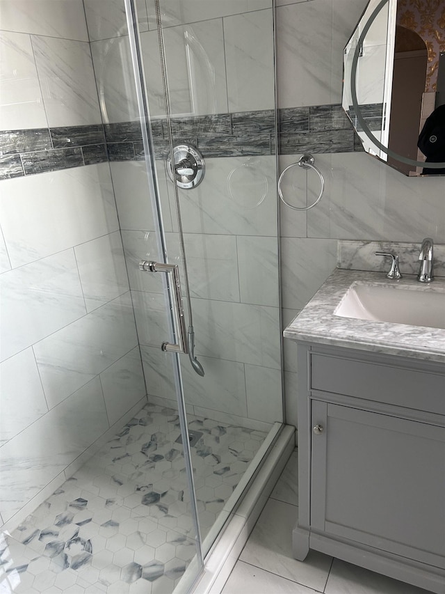 bathroom with vanity, tile walls, and a shower stall