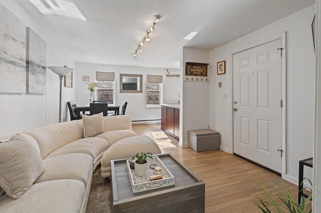 living room featuring light hardwood / wood-style floors, rail lighting, and a baseboard radiator