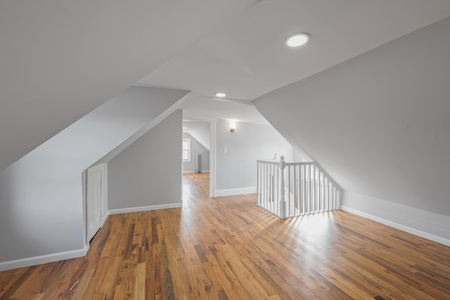 additional living space featuring hardwood / wood-style flooring and vaulted ceiling