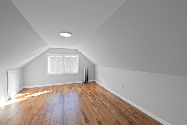 bonus room featuring lofted ceiling, wood-type flooring, and radiator heating unit