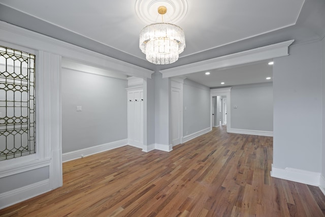 unfurnished dining area featuring an inviting chandelier and wood-type flooring