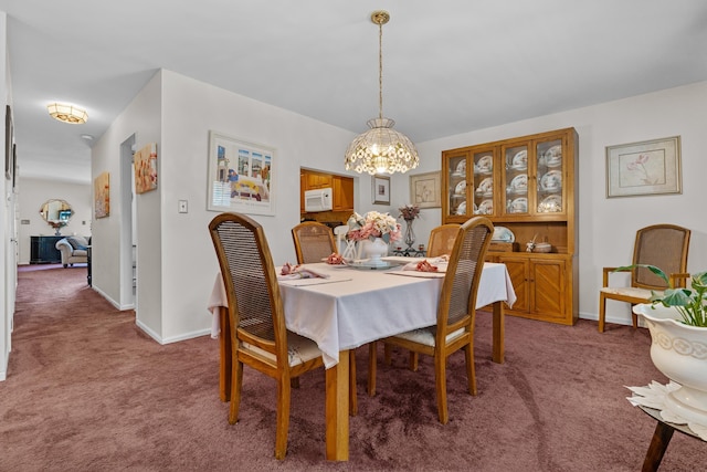 27 E 34th St, Bayonne, NJ 07002 - carpeted dining space with a chandelier and baseboards