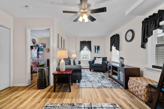 27 E 34th St, Bayonne, NJ 07002 - living area with healthy amount of natural light, ceiling fan, wood finished floors, and a baseboard heating unit