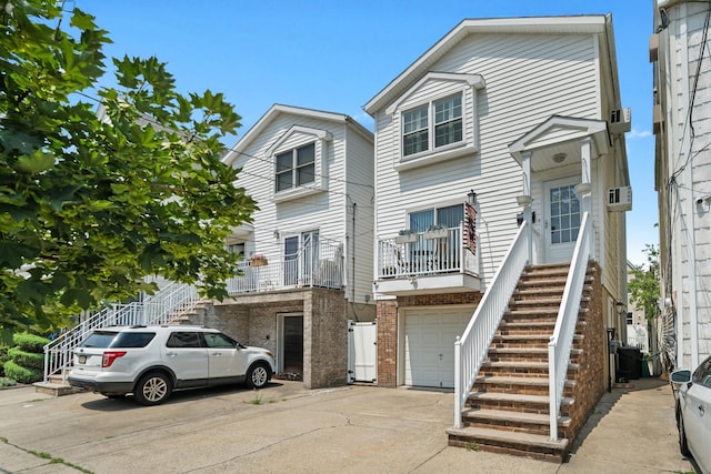 27 E 34th St, Bayonne, NJ 07002 - traditional home featuring stairs, concrete driveway, an attached garage, and brick siding