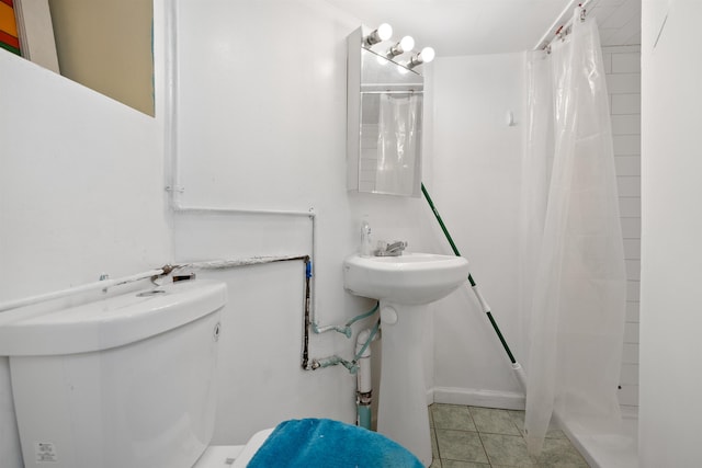 full bathroom with a stall shower, toilet, and tile patterned floors