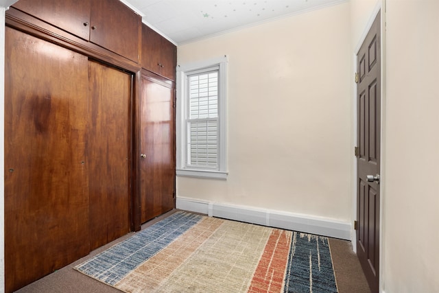 interior space with baseboards, a closet, dark carpet, and crown molding